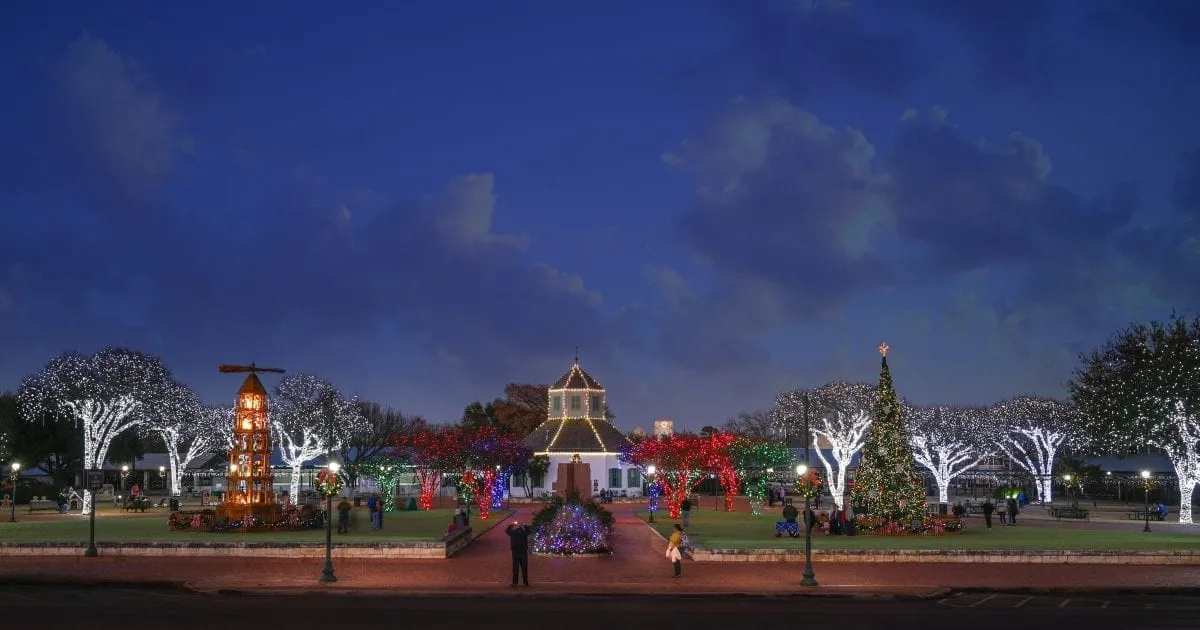 Families gathered around the lit Christmas tree and holiday displays at Marktplatz in Fredericksburg